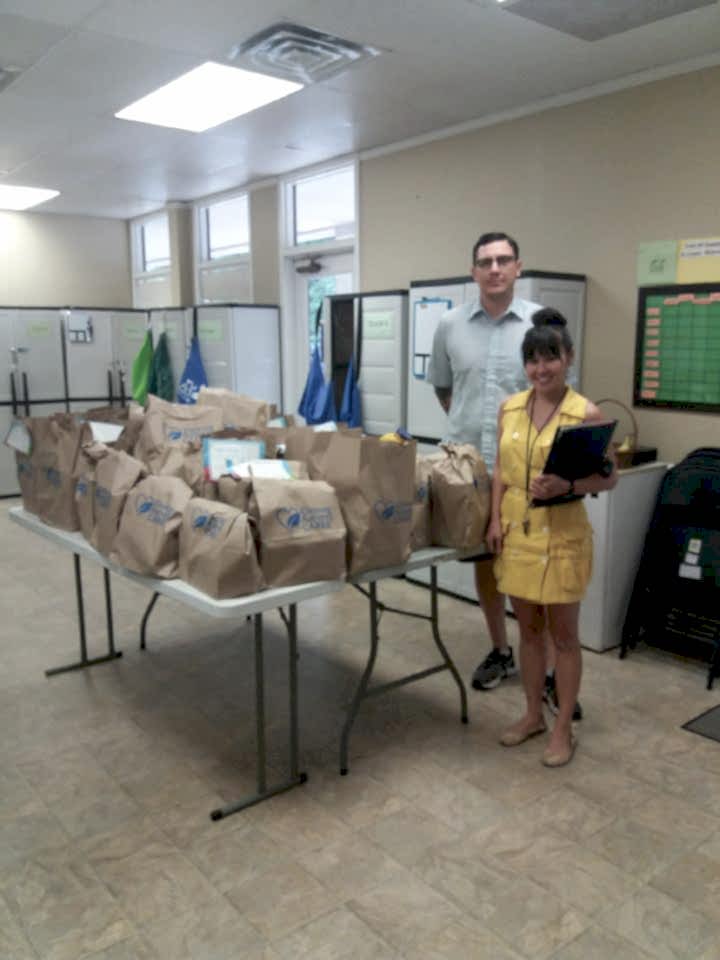 Members of the TCA Austin team pose with shopping carts full of donations collected for charity. 