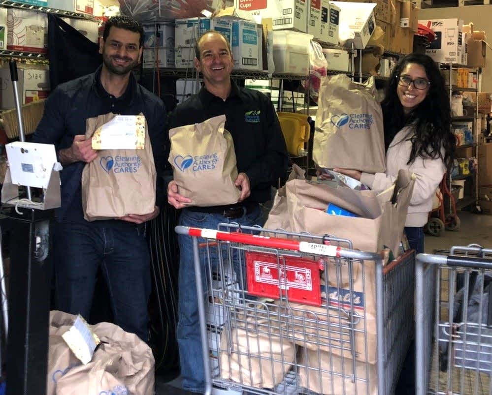 Members of the TCA Austin team pose with shopping carts full of donations collected for charity. 