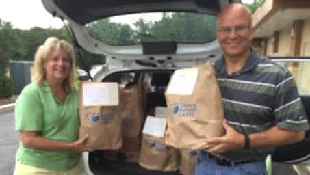 Members of the TCA Bowie team pose behind a car with the donations collected for local charities.