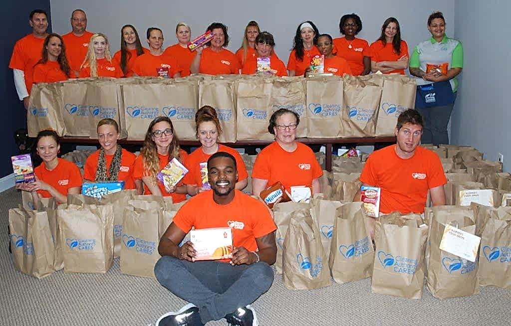 The TCA Downington team poses with the food donations collected for local charities.