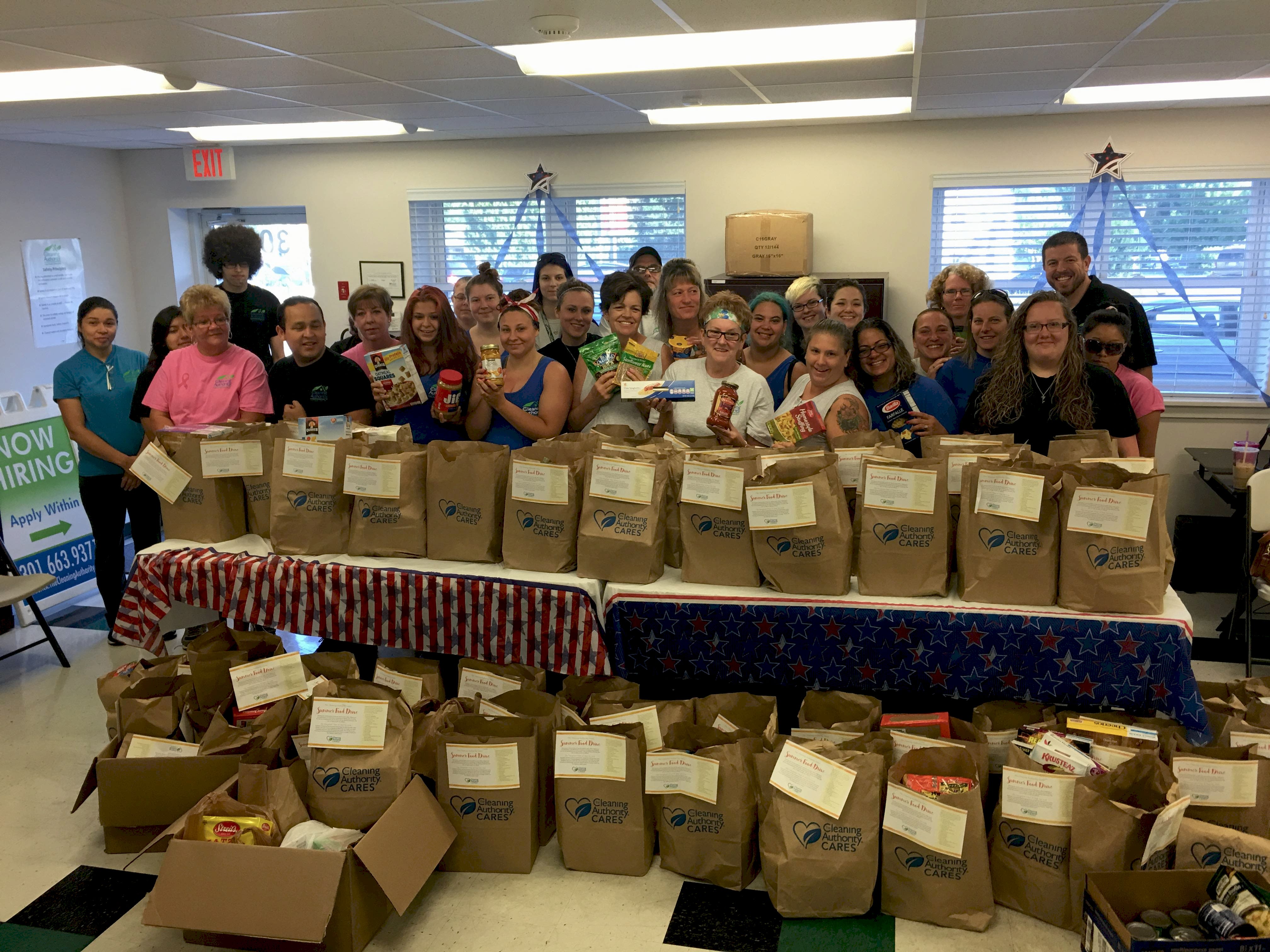 The TCA Frederick team poses with the food donations collected for local charities.