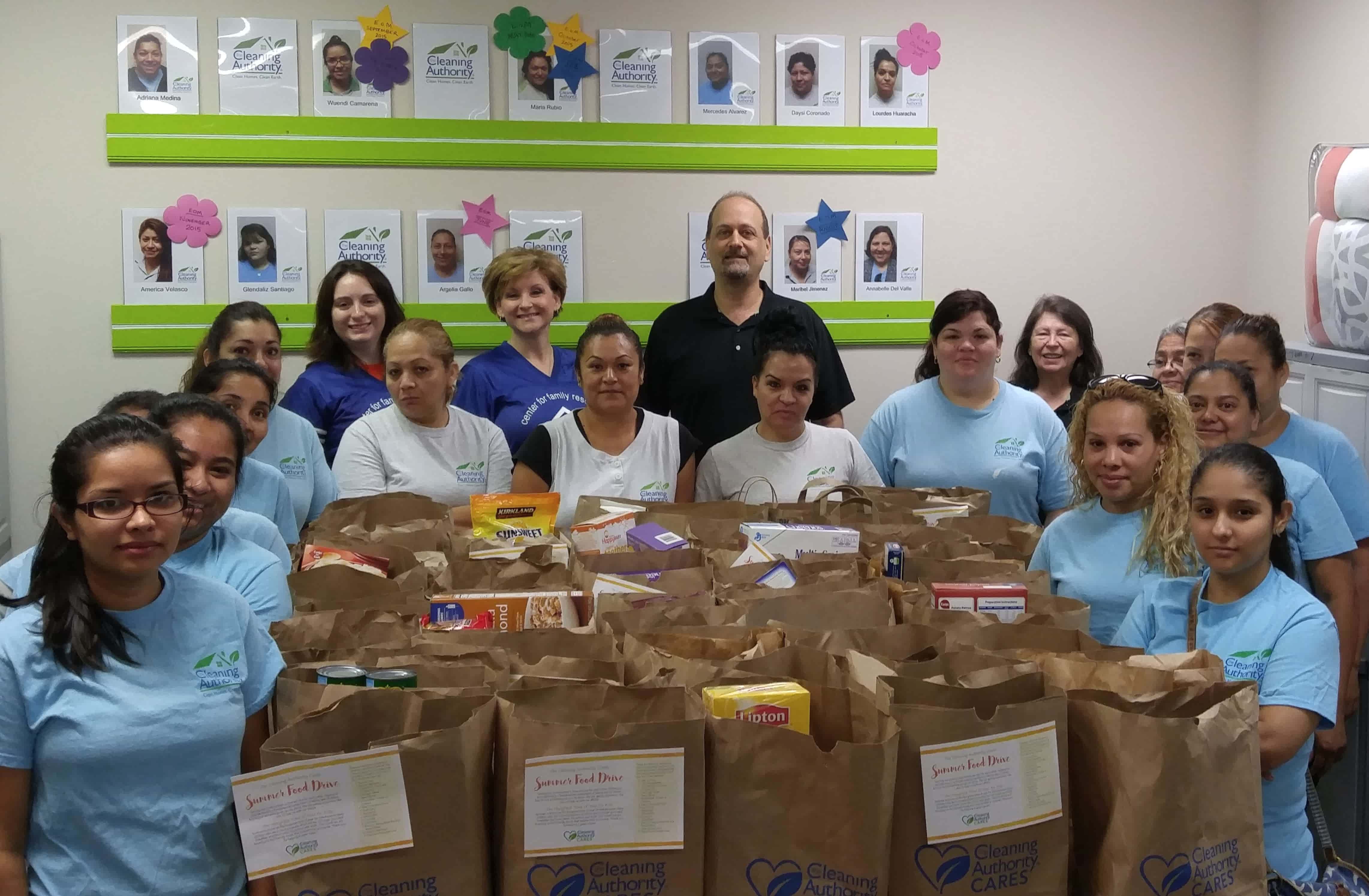 The TCA Marietta team stands in their office with donations collected for a local charity.