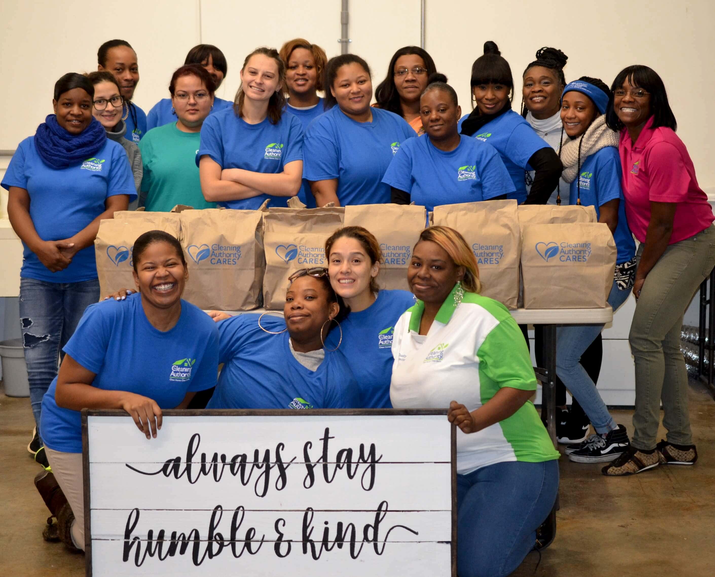 The TCA Norcross team stands in their office with donations collected for a local charity.