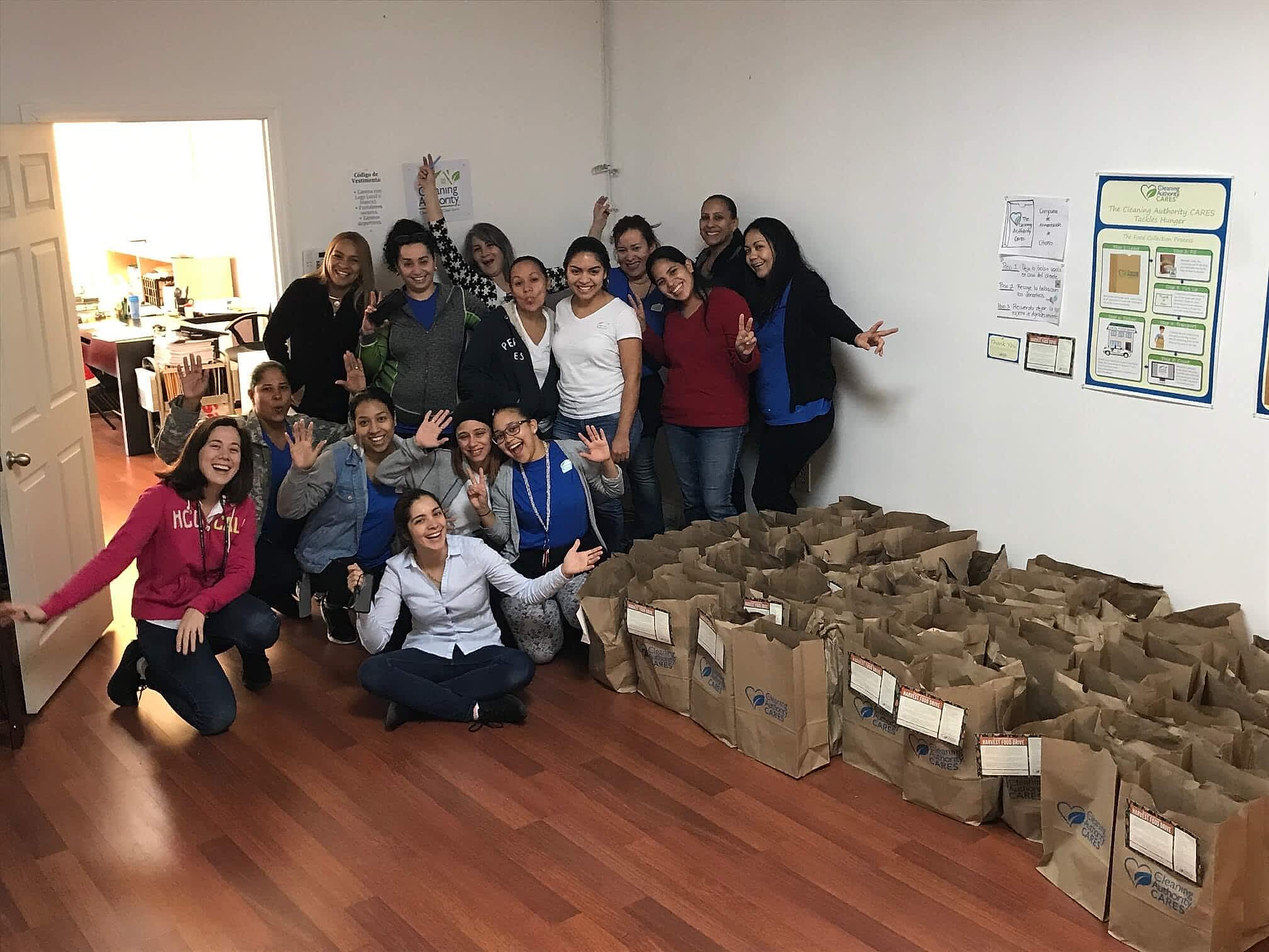 The TCA North Miami team stands in their office with donations collected for a local charity.