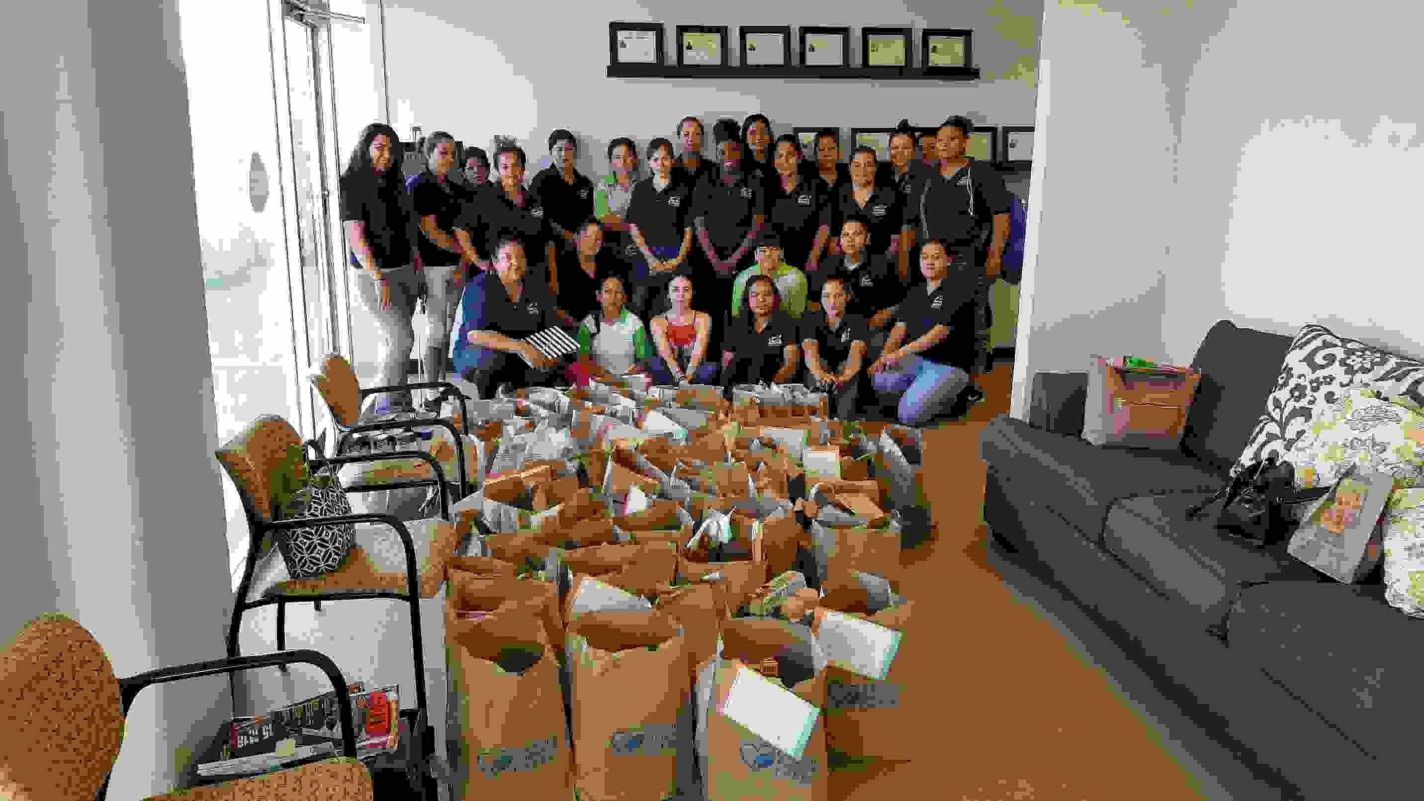 The TCA Oklahoma City team stands in their office with donations they collected for a local charity.