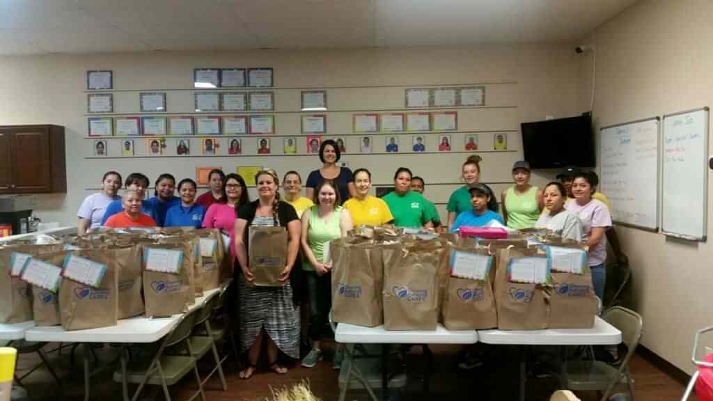 The TCA Olathe team stands in their office with donations collected for a local charity.