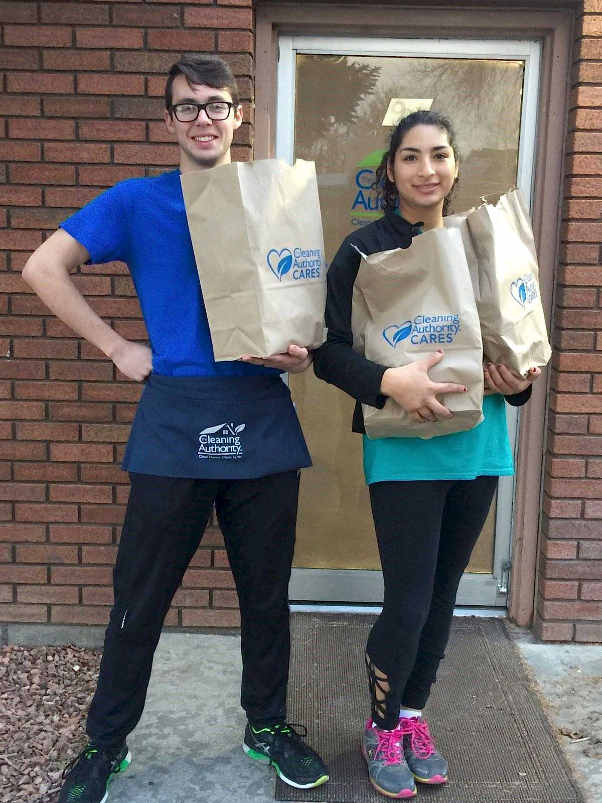 Two members of the TCA Provo team pose with donations collected for a local charity.