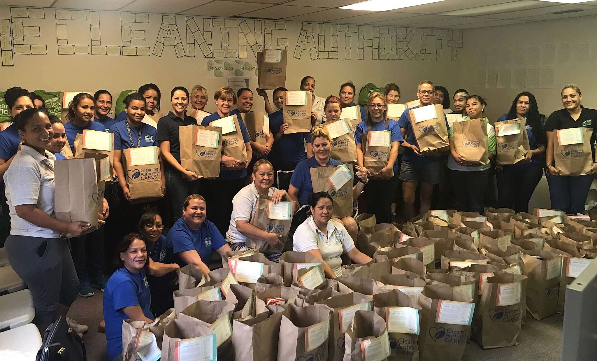 The TCA Tampa team poses in their offices with donations collected for a local charity.