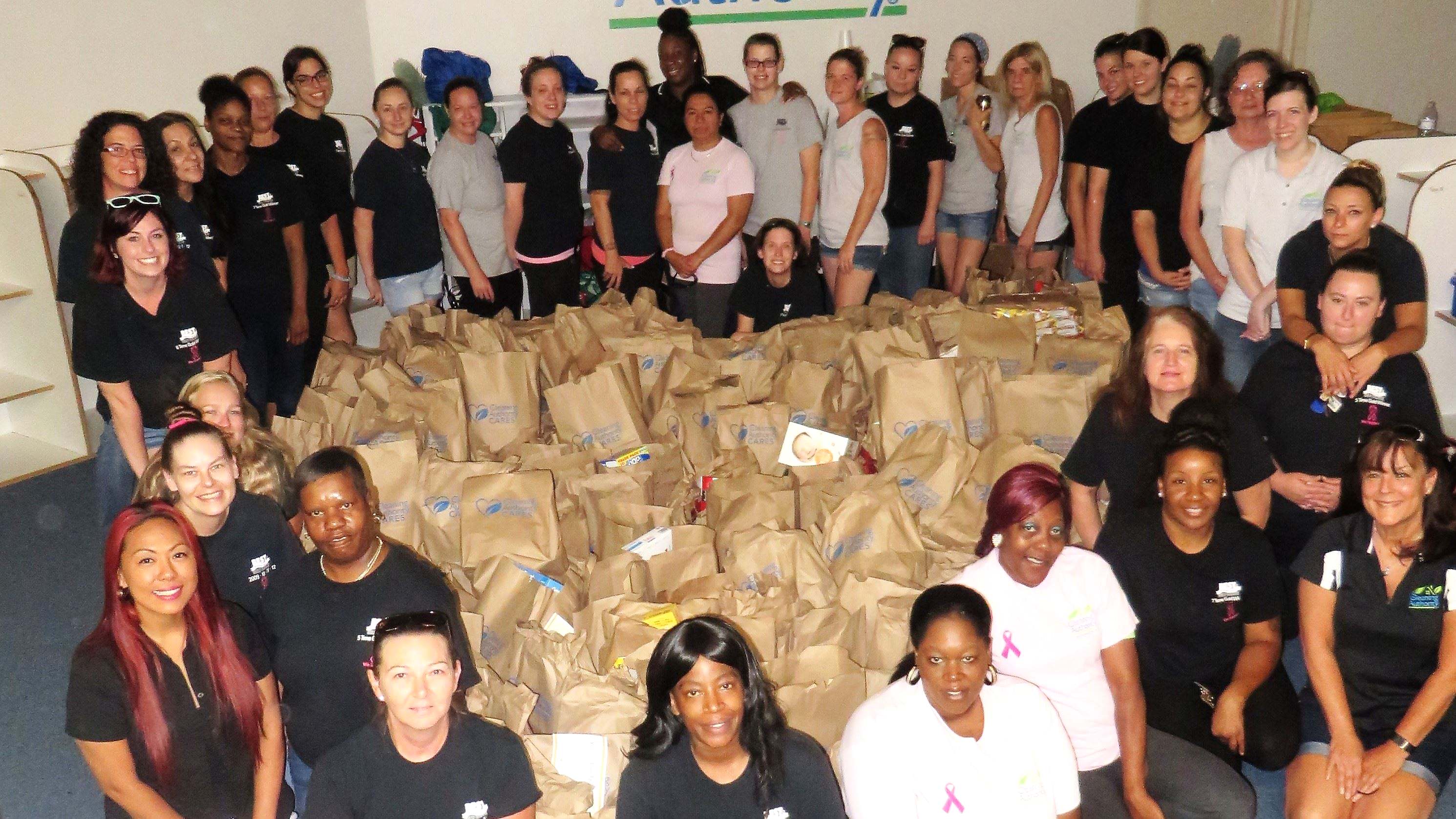 The TCA Virginia Beach team poses with donations collected for the Foodbank of Southeastern Virginia